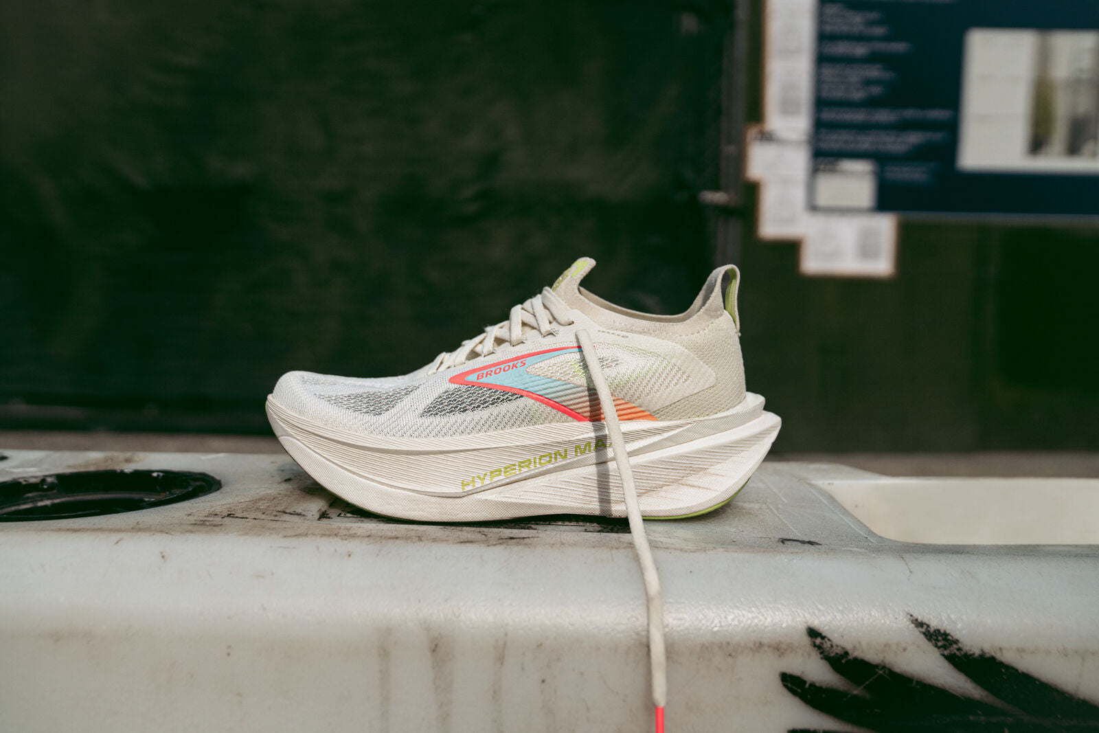 White running shoe with colorful accents on a concrete surface